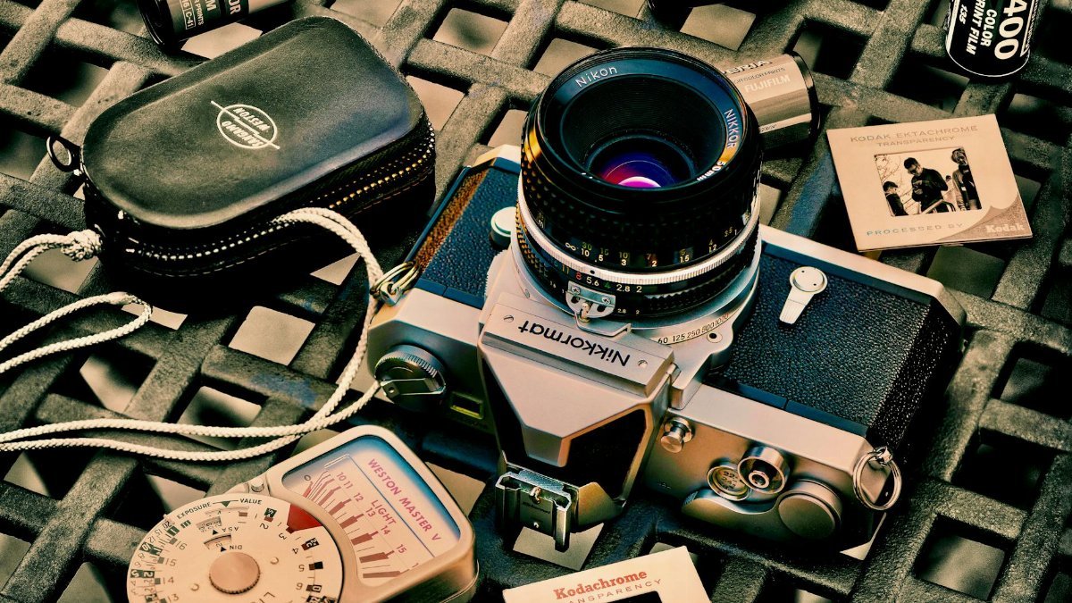 Analog camera with film rolls and accessories in a vintage aesthetic layout.