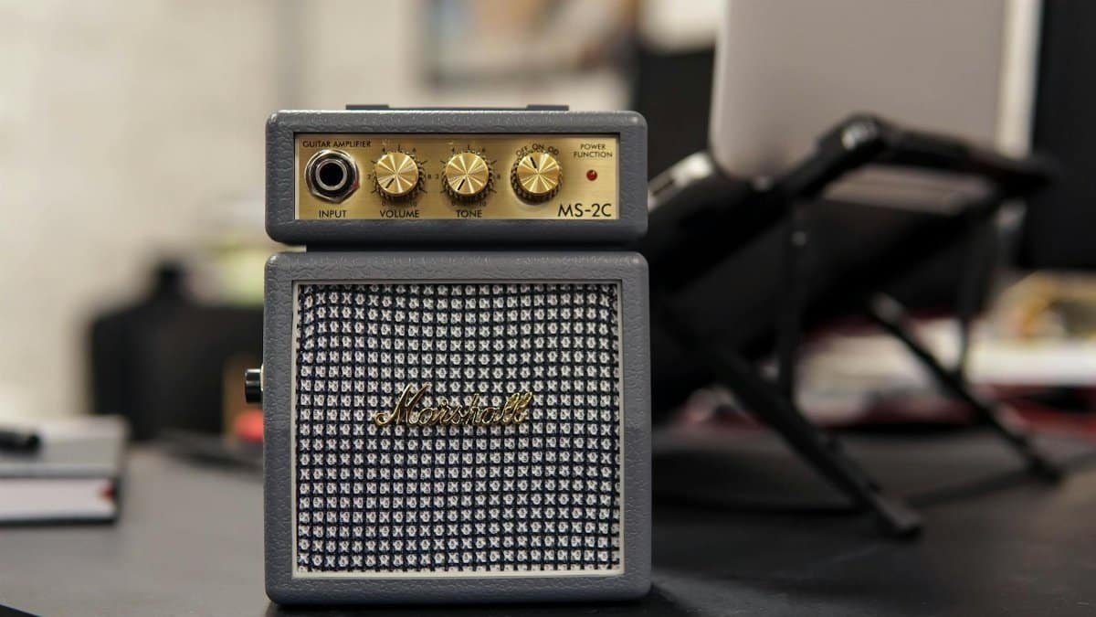 Marshall MS-2C mini guitar amplifier on a desk with blurred office background.