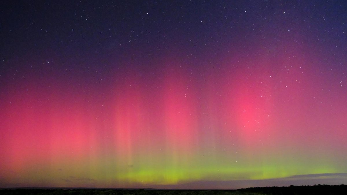 Capture of the vibrant southern lights over the serene landscape of Blind Bight, Australia.