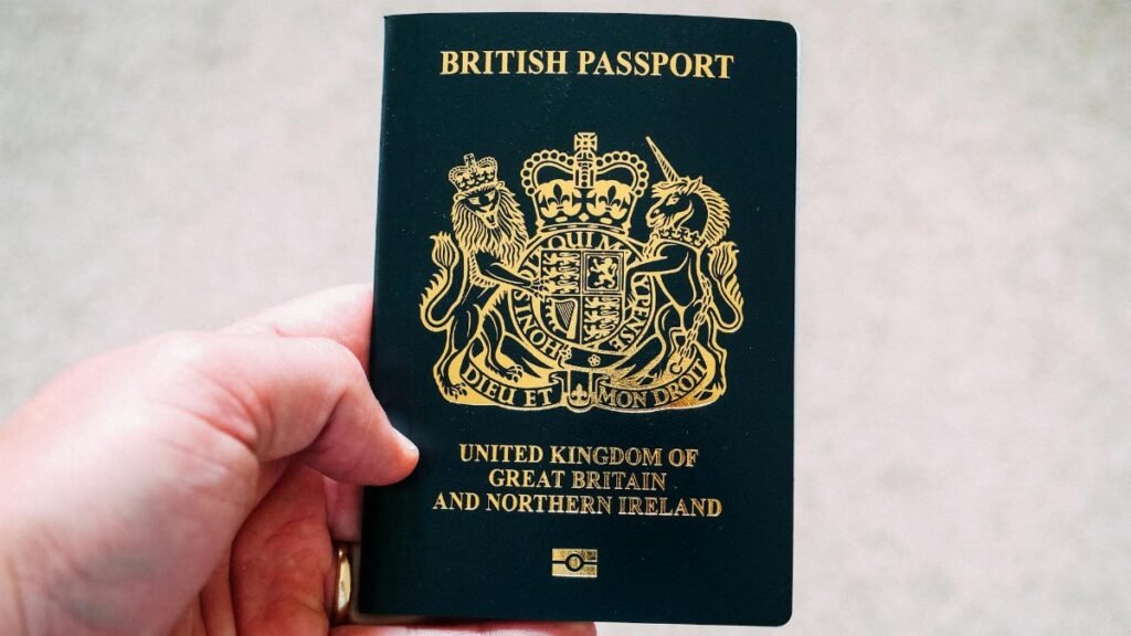 Close-up of a hand holding a British passport, symbolizing citizenship and travel.
