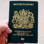 Close-up of a hand holding a British passport, symbolizing citizenship and travel.