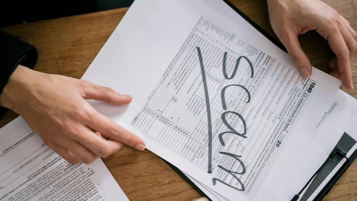 Documents highlighting tax fraud with the word 'scam' on tax forms.