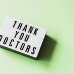From above of vintage light box with THANK YOU DOCTORS inscription placed on green surface