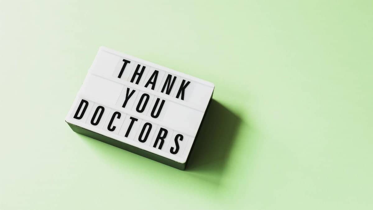 From above of vintage light box with THANK YOU DOCTORS inscription placed on green surface