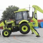 A vibrant ACE Phantom 4x4 backhoe loader is showcased in an outdoor setting in Faridabad, India.