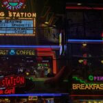 Neon signs of Filling Station Bar Cafe showcasing 24-hour service, breakfast, and coffee.