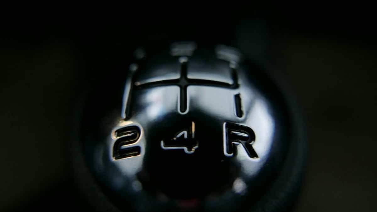 Detailed view of a manual shift knob inside a vehicle, showcasing gear arrangements.