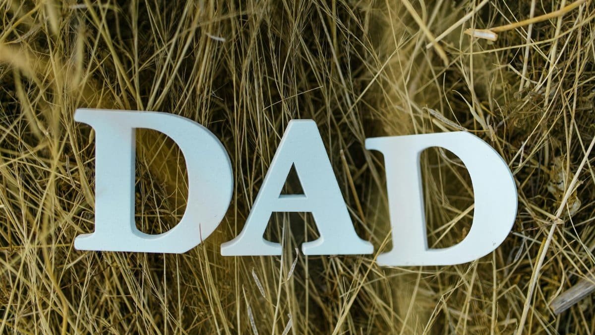 Stylized letters spelling 'DAD' set against a background of rustic hay, perfect for Father's Day themes.