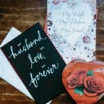 Heartfelt Valentine's Day cards and a heart-shaped chocolate box on a wooden surface, perfect for a romantic gift.