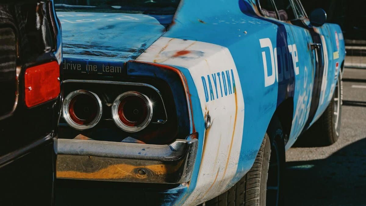 Classic blue Dodge car with racing decals seen at an outdoor auto show. Nostalgic and vintage appeal.