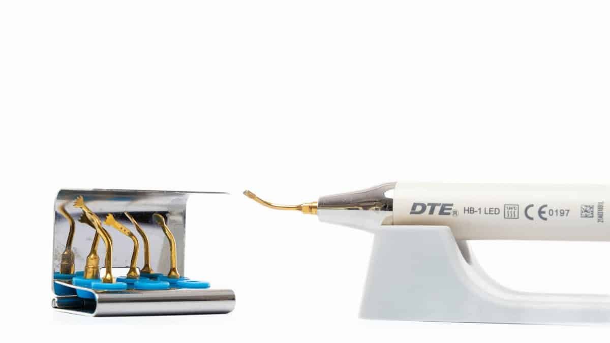 Close up of a dental ultrasonic scaler tool with multiple insert tips for dental hygiene.