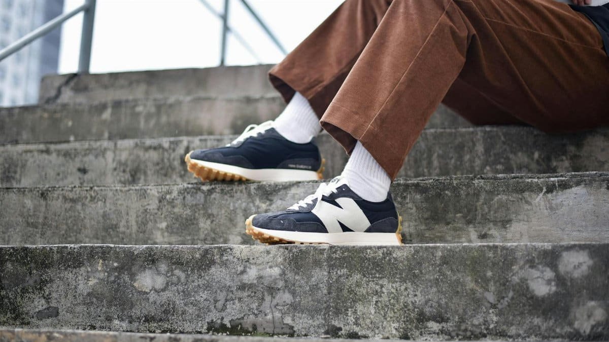 Close-up of a person wearing sneakers and brown pants sitting on concrete steps in Kuala Lumpur.