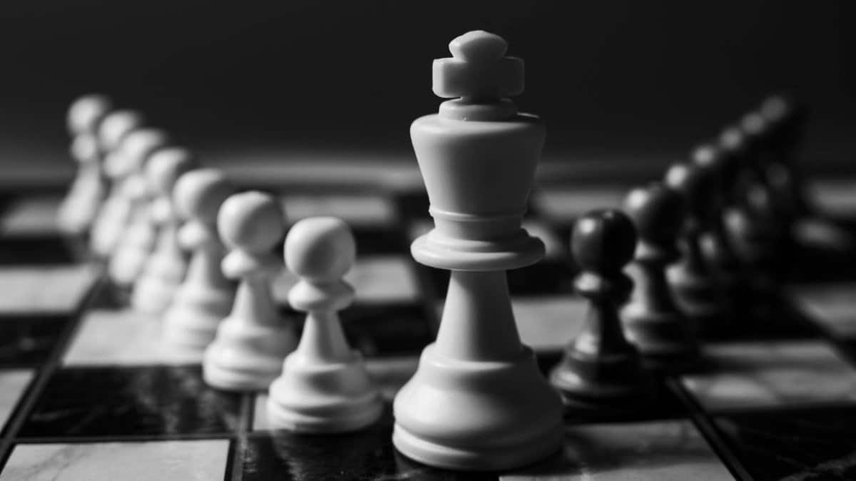A close-up view of chess pieces on a board, focusing on a king piece, illustrating strategy and decision-making.