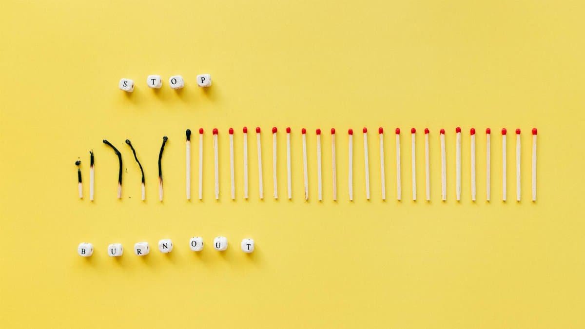 Burned and unburned matches arranged on a yellow background spelling 'Stop Burnout'.