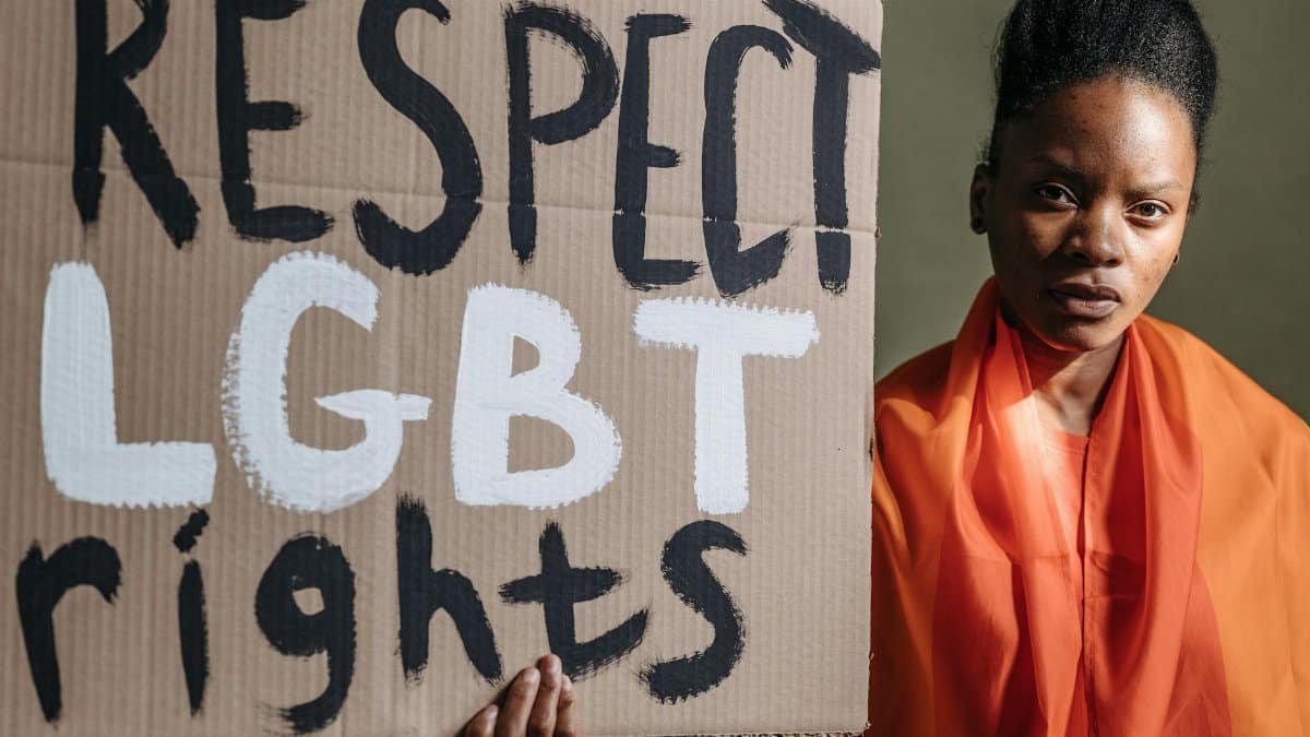 Woman holding a sign advocating for LGBT rights, highlighting social justice.