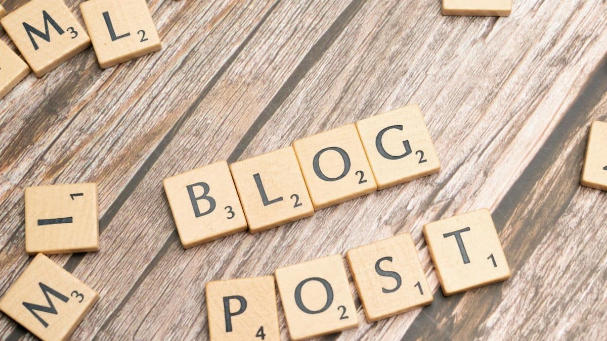 Wooden letter tiles spelling 'Blog Post' on a wooden background, ideal for online media concepts.