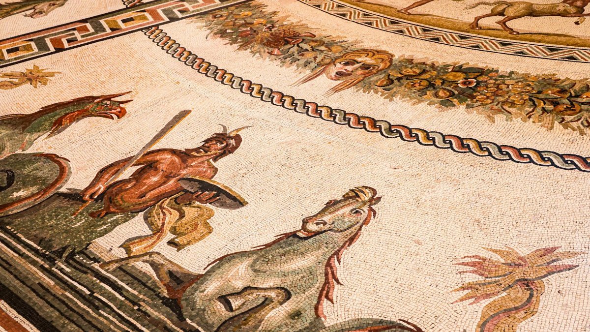 Intricate Roman mosaic featuring mythological figures and designs, showcasing ancient artistry.