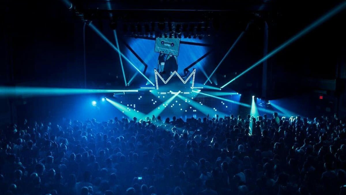Vibrant nightclub scene with a crowd enjoying the dynamic light show at a rave party.