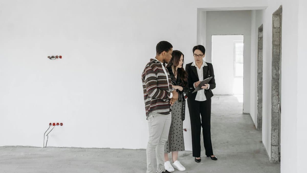 A couple and realtor discuss details in an unfinished property. Ideal for real estate themes.