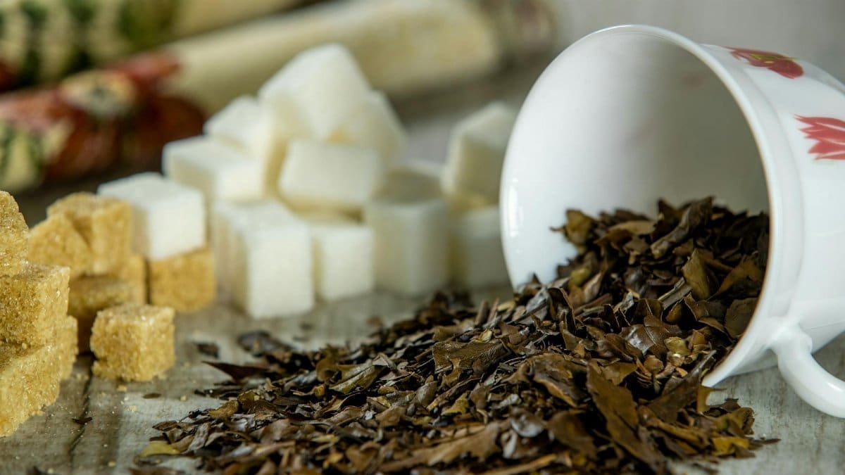 Close-up of spilled tea leaves and sugar cubes, perfect for still life compositions.