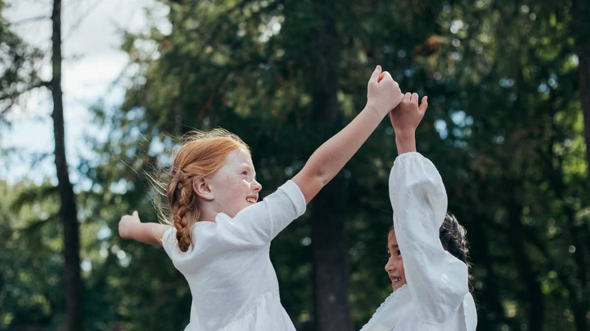 Two girls enjoying friendship and play outdoors, embracing childhood joy.