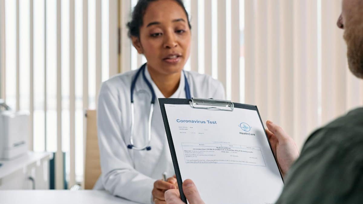 Doctor having a consultation with a patient over coronavirus test results in a medical office.