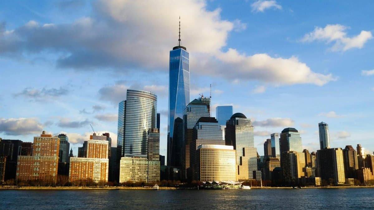 Stunning view of New York City skyline featuring the iconic One World Trade Center at sunset.