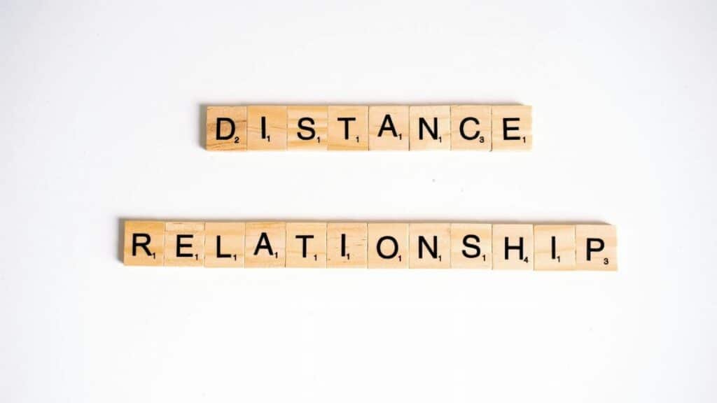 Conceptual image of Scrabble tiles spelling 'Distance Relationship' on a white background.