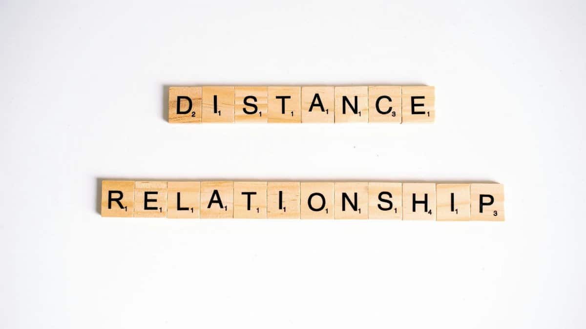 Conceptual image of Scrabble tiles spelling 'Distance Relationship' on a white background.