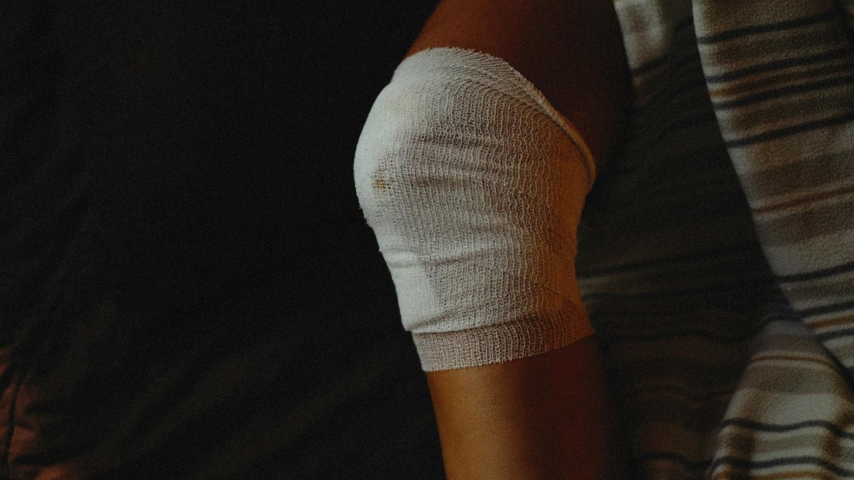 A detailed view of a bandaged knee indicating injury care and healing process.