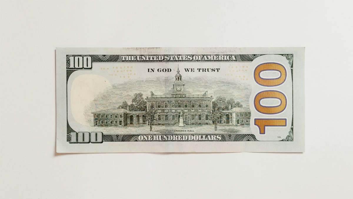 Detailed close-up of an American one hundred dollar bill on a neutral white background.