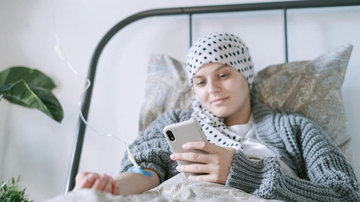 A woman undergoing cancer treatment relaxing in bed, capturing hope and resilience.