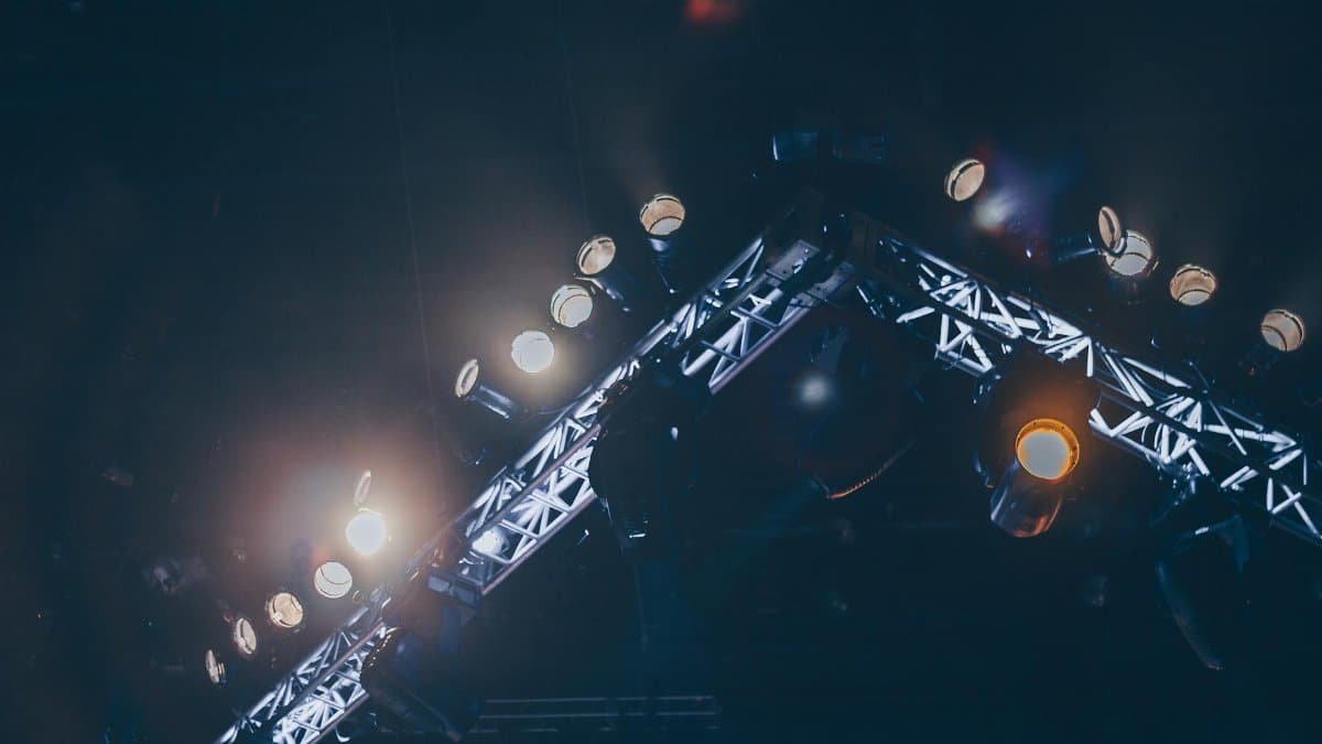 Bright stage lights illuminate a concert venue, creating a vivid and celebratory atmosphere.