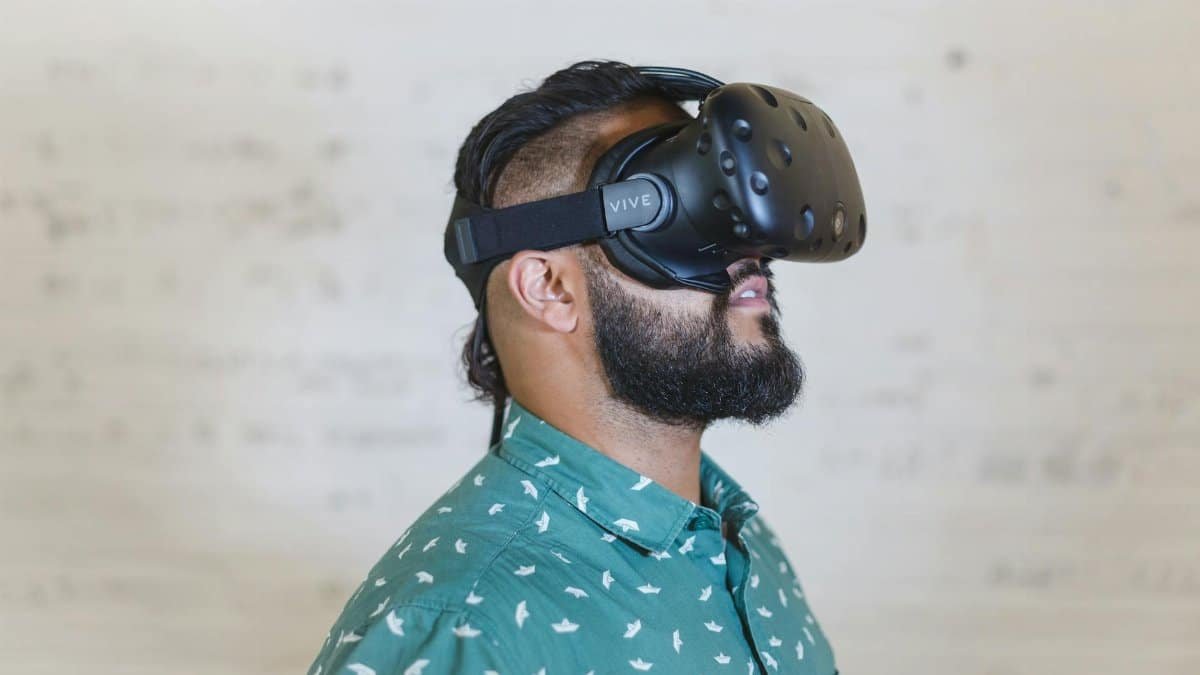 Adult male using a virtual reality headset for immersive experience indoors.