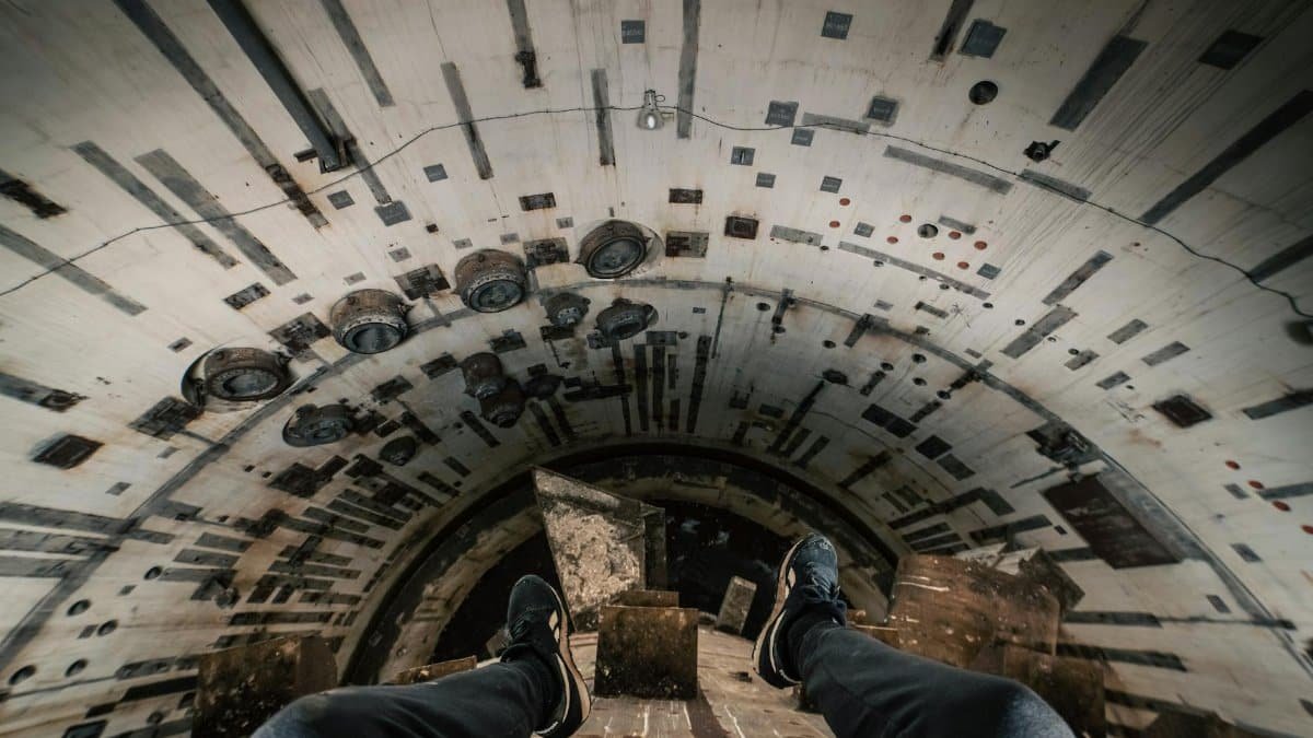 Adventurous view of a person exploring an underground tunnel in Spain, showcasing urban exploration.