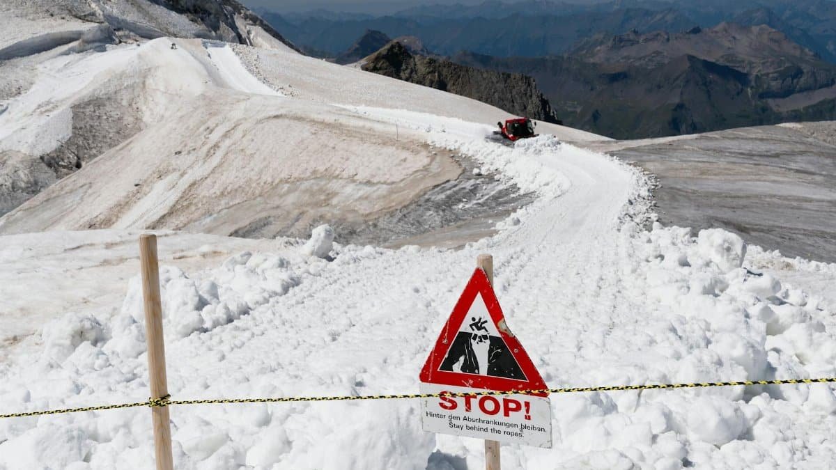Snow-covered trail with avalanche warning sign on Jungfrau, Switzerland.