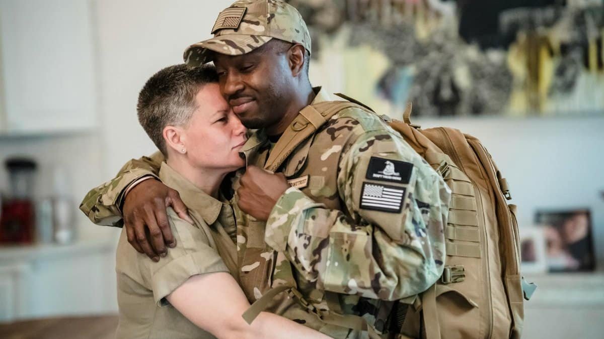 An emotional farewell embrace between soldiers indoors, showing love and support.