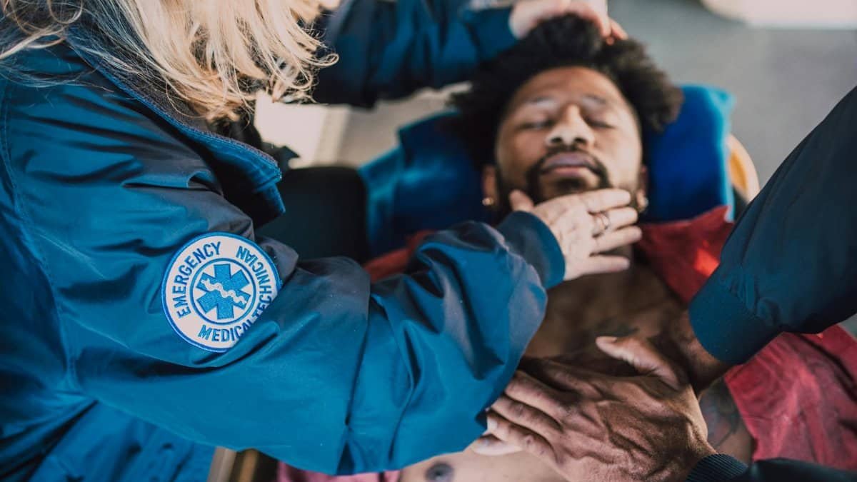 Paramedics performing CPR on an unconscious patient in an emergency situation.