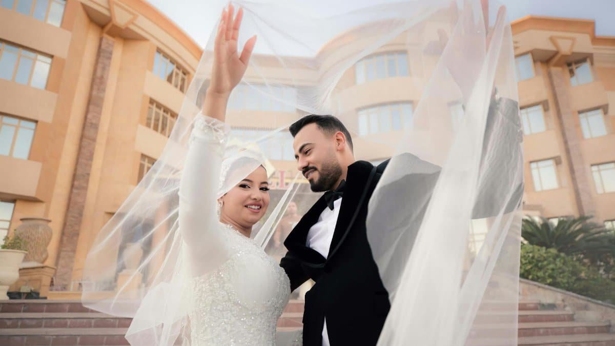 A joyful couple celebrates their wedding outdoors, capturing love and elegance.