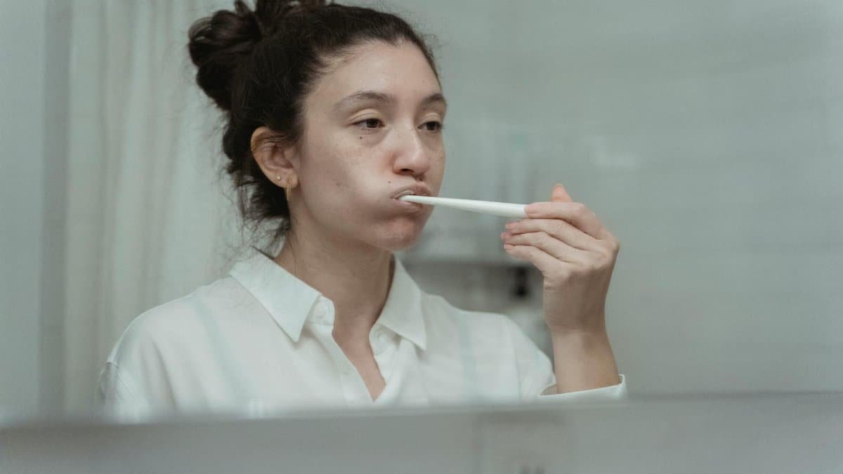 Side view of a woman brushing her teeth, focusing on dental care and hygiene.