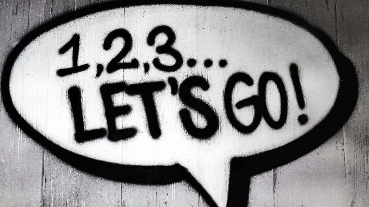 Black and white street art featuring a bold motivational message in a speech bubble.