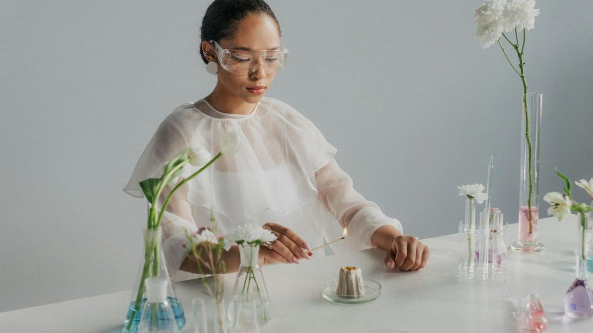 Scientist experimenting with flowers and glassware, blending science and nature in a studio setting.