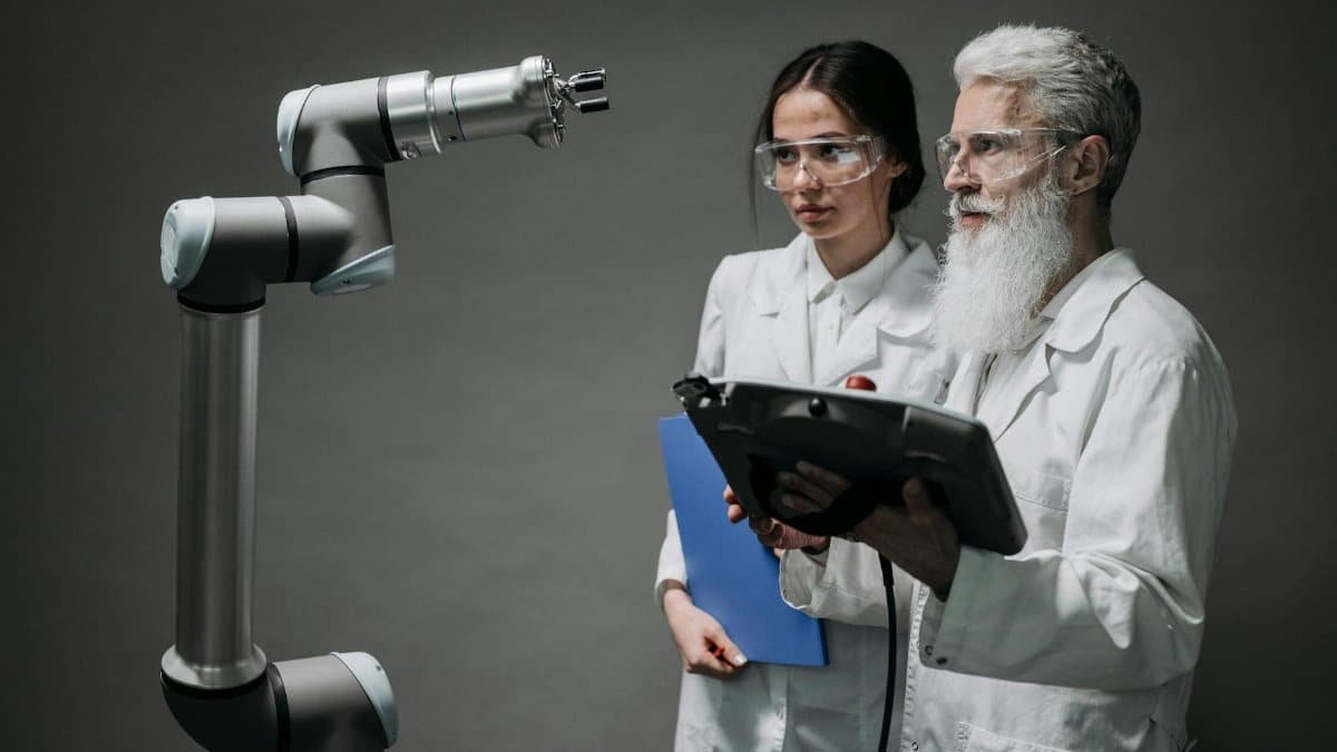 Researchers examining a robotic arm, showcasing technology and innovation.