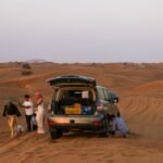 A group enjoying a scenic Sahara desert adventure with a 4x4 vehicle.
