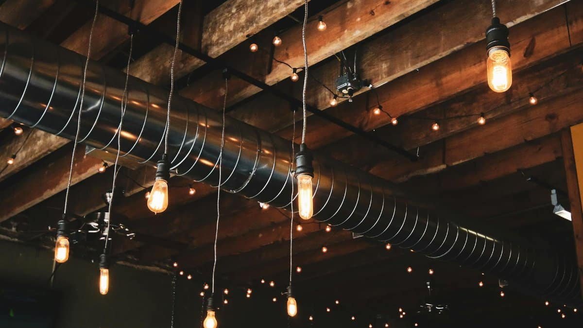 Wooden ceiling featuring industrial hanging lights and exposed ductwork for a modern rustic look.
