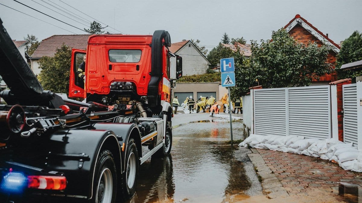 Emergency vehicles and personnel addressing urban flooding caused by heavy rains.