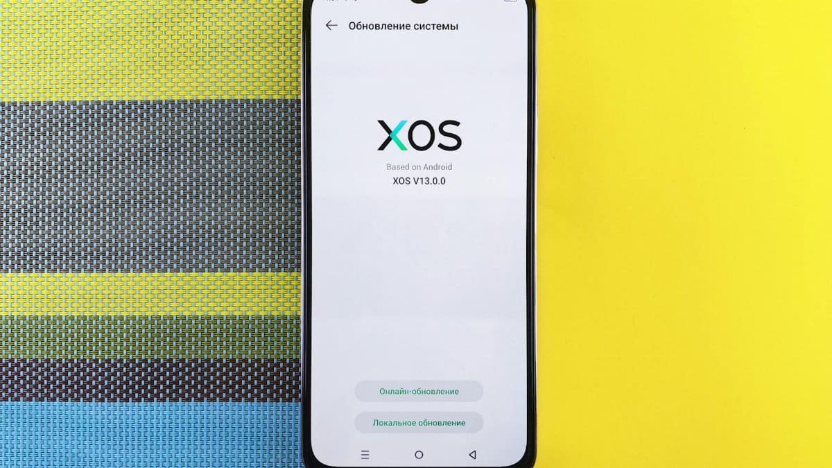 Smartphone on colorful background showing XOS version update, based on Android.