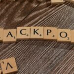 Wooden letter tiles spelling 'JACKPOT' on a textured wooden surface, representing winning or success.