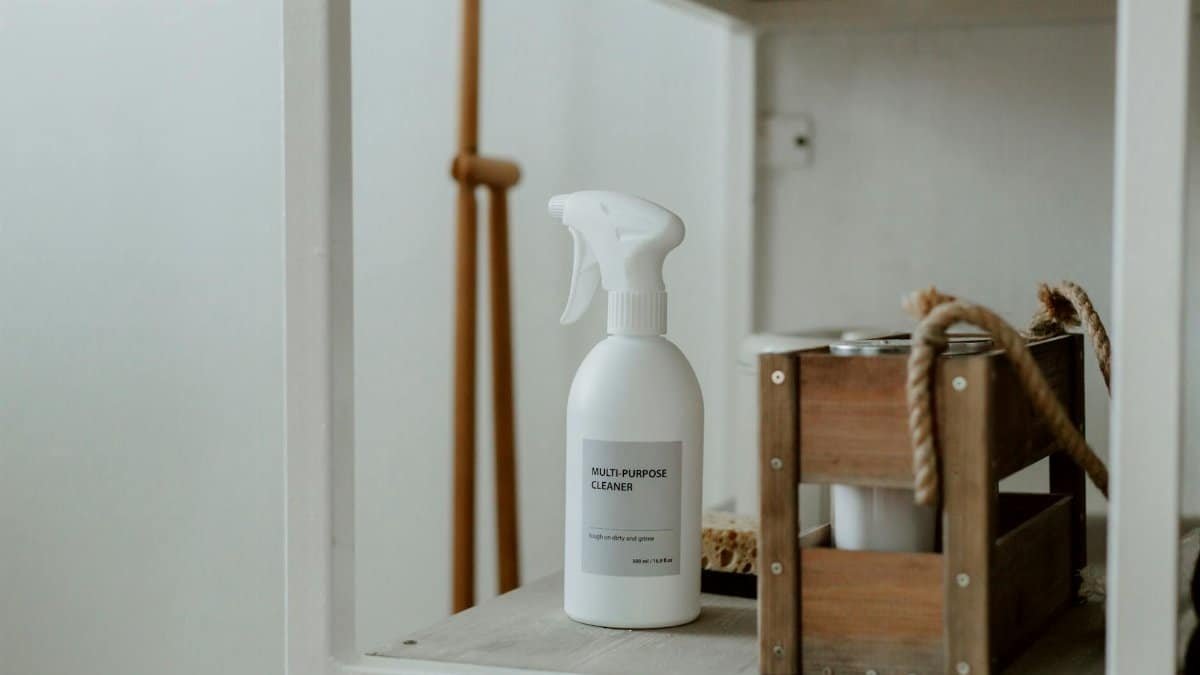 Clean white shelf with a spray cleaner and wooden caddy, perfect for home organization.