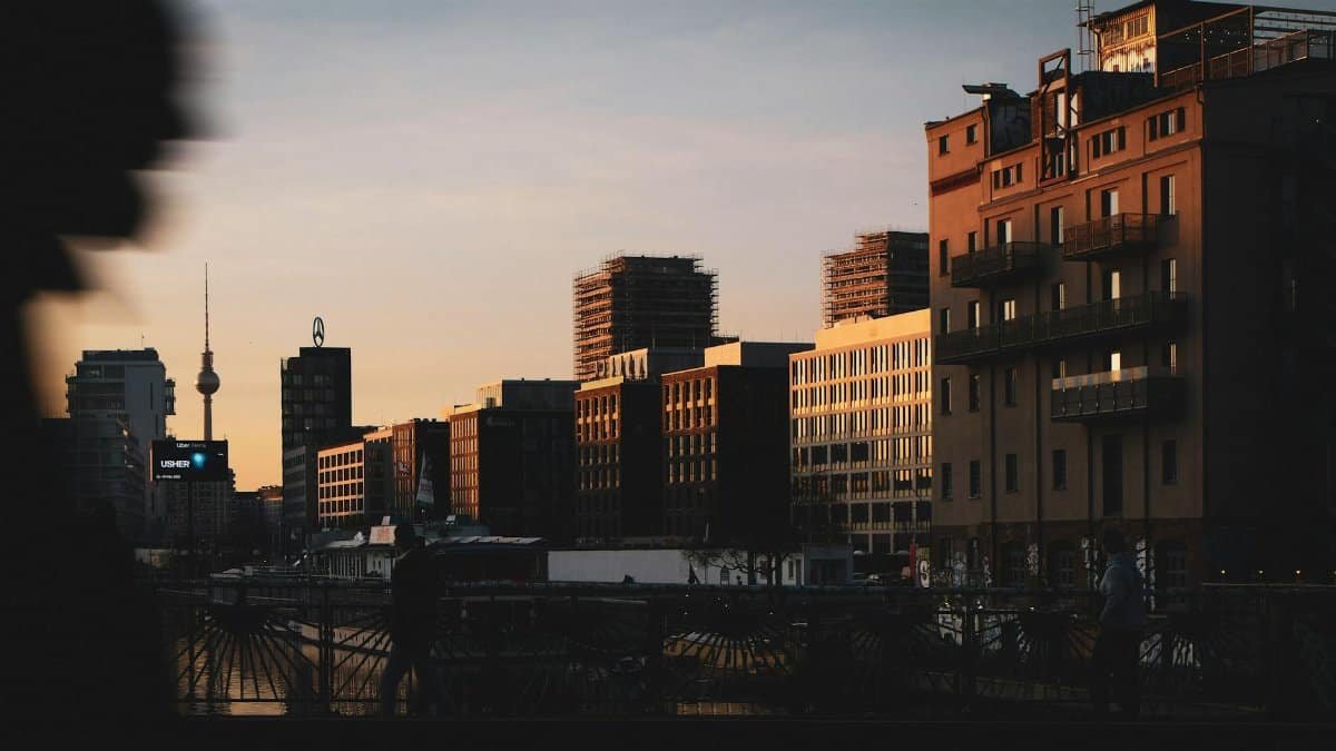 Twilight view of Berlin's skyline with the iconic TV tower and silhouetted buildings.